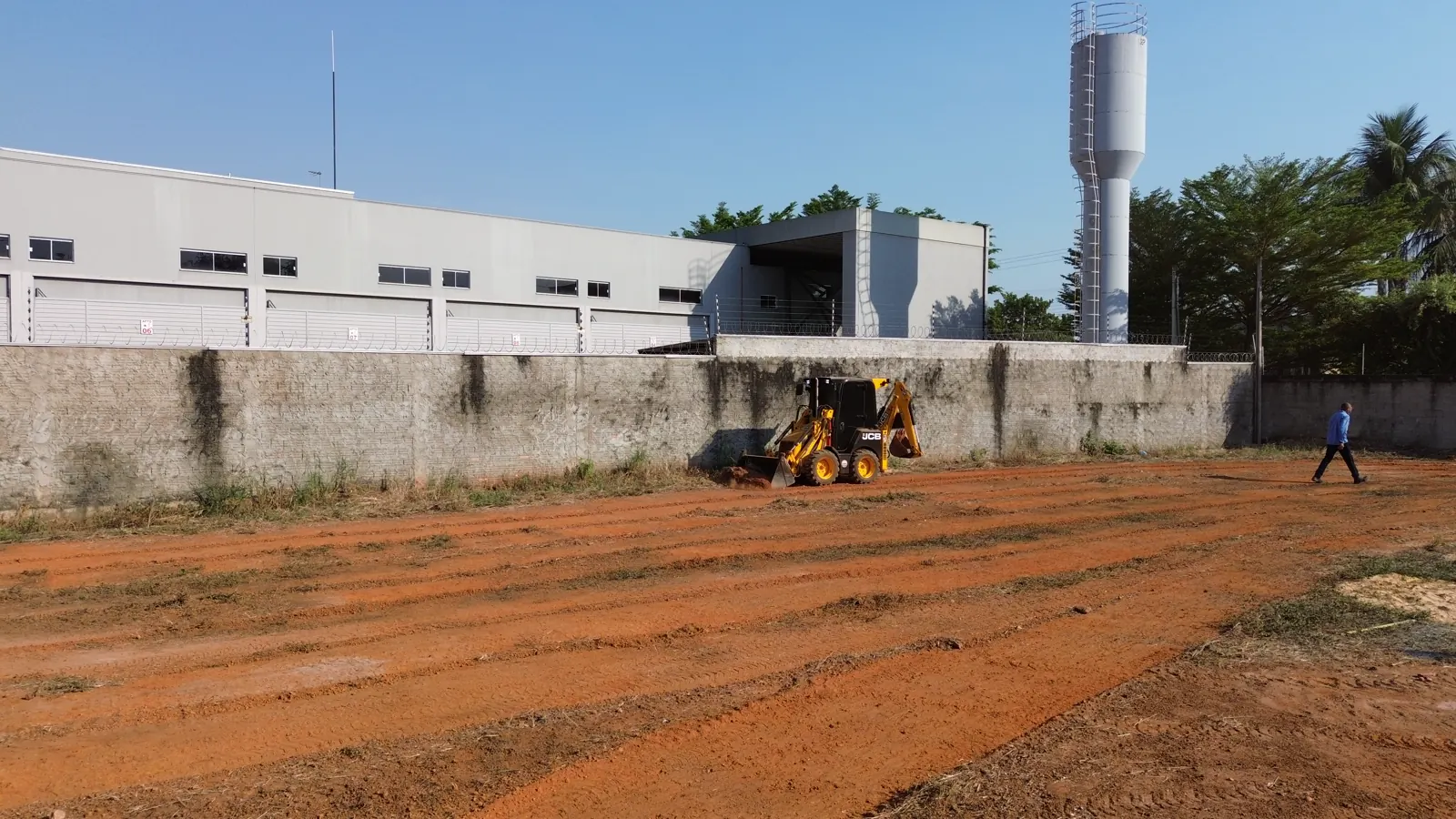 Mini retroescavadeira amarela da Renzzo trabalhando em um terreno